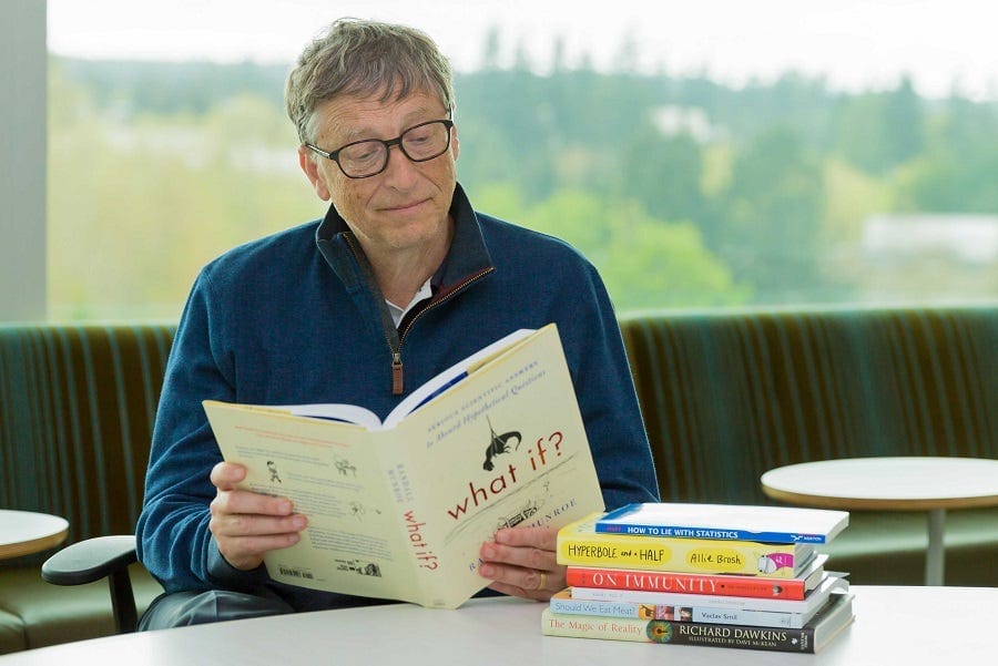 Bill Gates engrossed in an essential read at a table.