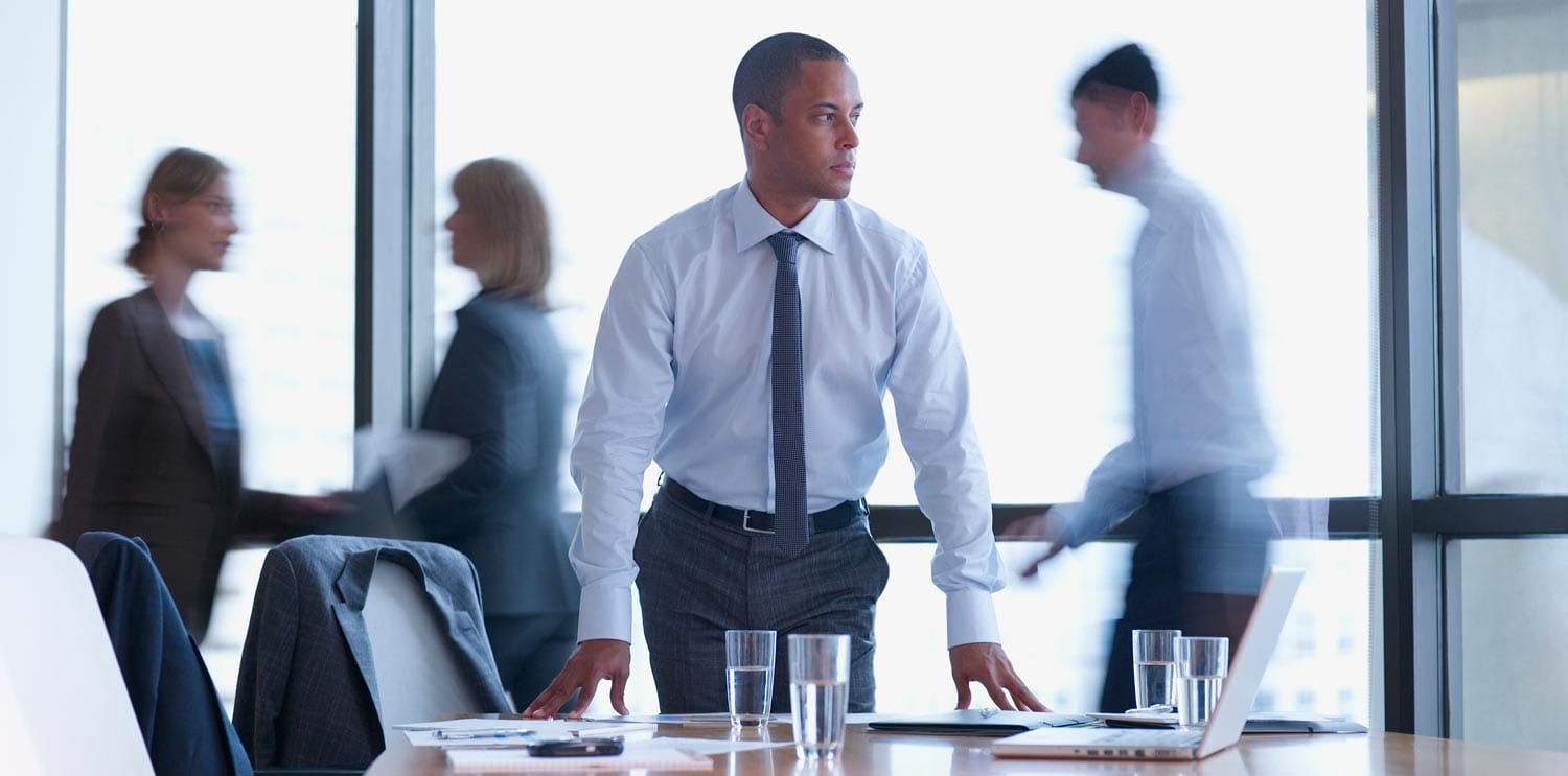 A group of people engaged in ethical decision-making around a table in a conference room.