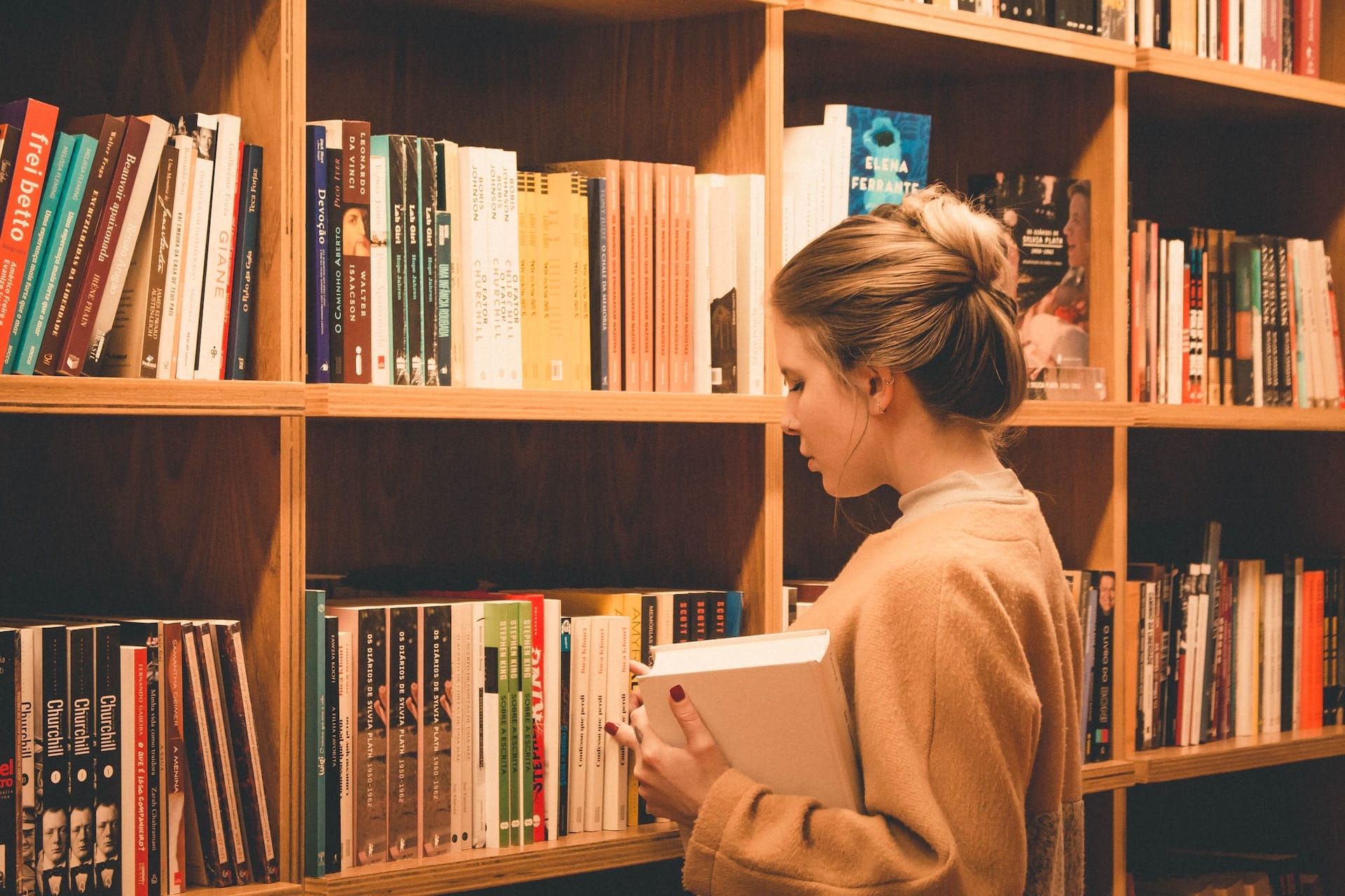 A woman immersed in a book in the library.