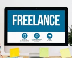 A computer monitor displays the word "FREELANCE" in large letters, with icons and text below it; colored sticky notes and office supplies are on the desk, reflecting tools commonly used by solopreneurs and users of freelance platforms.